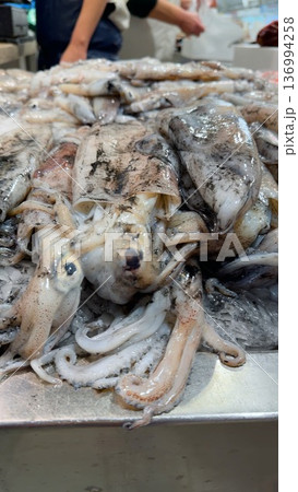 Market stall showcases glistening squid ready for purchase 136994258