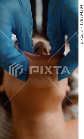 Cosmetic practitioner performing jawline filler on female patient Cosmetic practitioner performing jawline filler on female patient 136994294