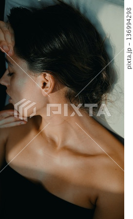 Woman relaxes peacefully post therapy with soft lighting and shadows 136994298