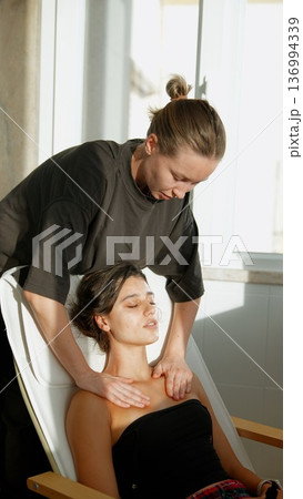 Tranquil woman receives calming neck and shoulder therapy session 136994339