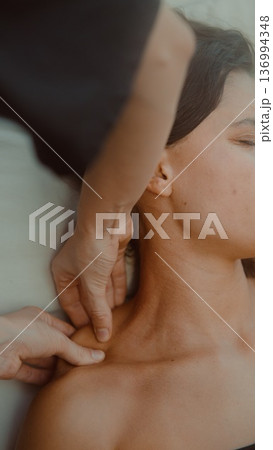 Professional therapist performing lymphatic drainage with calm demeanor Professional therapist performing lymphatic drainage with calm demeanor 136994348