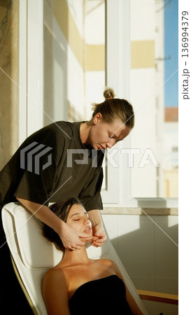 Tranquil nighttime skincare involving tender massage and calming serum use 136994379