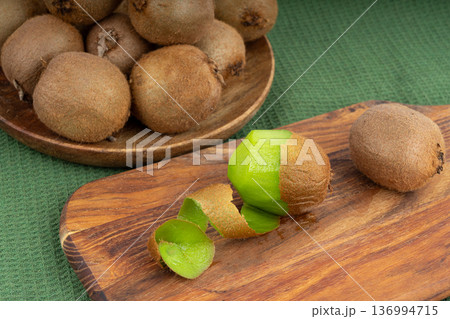 Kiwi fruit peel on wood cutting board 136994715