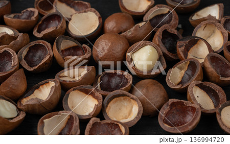 Macadamia nuts pattern. Natural raw peeled macadamia seeds and shells 136994720