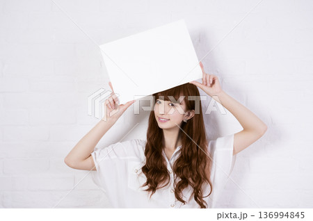 ホワイトボードをかかげる女性 136994845