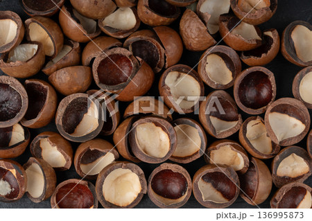 Macadamia nuts pattern. Natural raw peeled macadamia seeds and shells Macadamia nuts pattern. Natural raw peeled macadamia seeds and shells 136995873