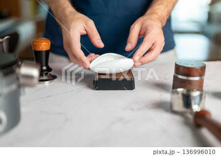 Man Using A Scale To Measure Coffee Beans For Espresso Preparation Man Using A Scale To Measure Coffee Beans For Espresso Preparation 136996010
