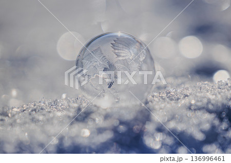 雪上に浮かぶ氷玉と玉ボケが美しい冬の背景 雪上に浮かぶ氷玉と玉ボケが美しい冬の背景 136996461