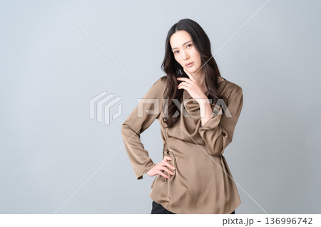 グレー背景でスキンケアをする女性ビューティー グレー背景でスキンケアをする女性ビューティー 136996742