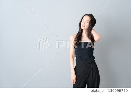 グレー背景でスキンケアをする女性のビューティーイメージ グレー背景でスキンケアをする女性のビューティーイメージ 136996750