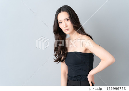 グレー背景でスキンケアをする女性のビューティーイメージ 136996758