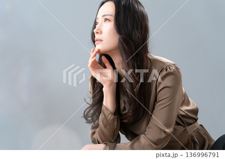 グレー背景でスキンケアをする女性のビューティーイメージ 136996791