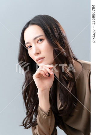 グレー背景でスキンケアをする女性のビューティーイメージ 136996794