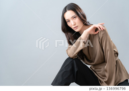 グレー背景でスキンケアをする女性のビューティーイメージ 136996796