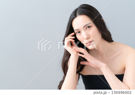 グレー背景でスキンケアをする女性のビューティーイメージ グレー背景でスキンケアをする女性のビューティーイメージ 136996802