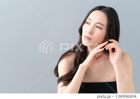 グレー背景でスキンケアをする女性のビューティーイメージ 136996804