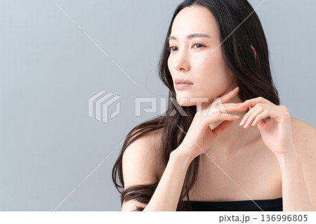 グレー背景でスキンケアをする女性のビューティーイメージ 136996805