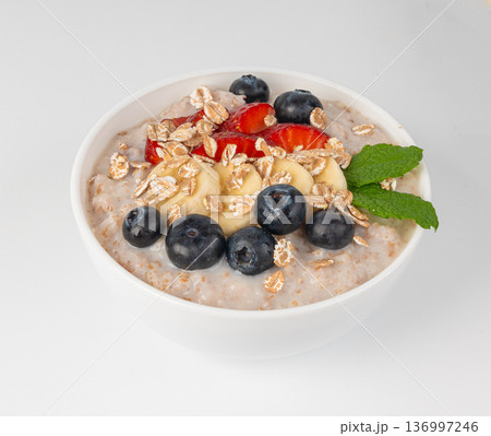 Cooked spelt in bowl isolated. Oatmeal milk porridge with fruits and berries Cooked spelt in bowl isolated. Oatmeal milk porridge with fruits and berries 136997246