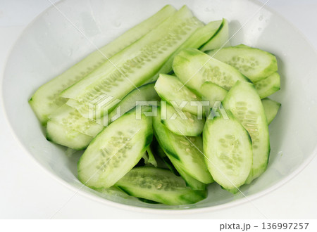Cucumber cuts and slices in white bowl close up Cucumber cuts and slices in white bowl close up 136997257