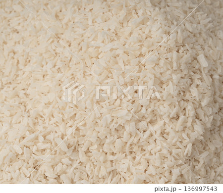 Grated coconut powder. Dry coco flakes pile, shredded desiccated coconut, tropical fruit chips 136997543