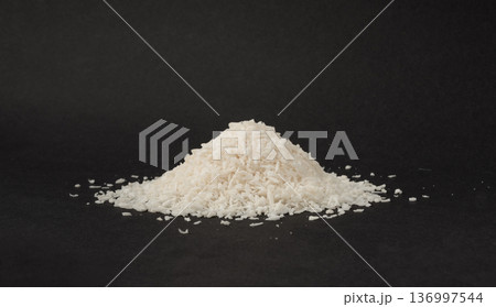 Grated coconut powder. Dry coco flakes pile, shredded desiccated coconut, tropical fruit chips 136997544