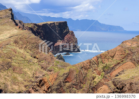 Deep volcanic ravine at Ponta de Sao Lourenco Madeira, arid cliffs frame narrow Atlantic opening Deep volcanic ravine at Ponta de Sao Lourenco Madeira, arid cliffs frame narrow Atlantic opening 136998370
