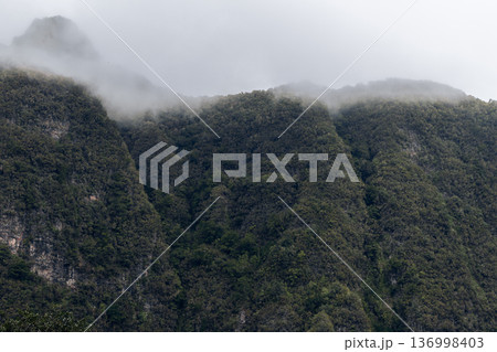 Cloud capped ridges on Madeira Portugal, green volcanic slopes and sheer cliffs fade into fog 136998403