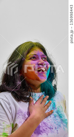 Close up portrait of woman covered in colorful Holi powder. 136998443