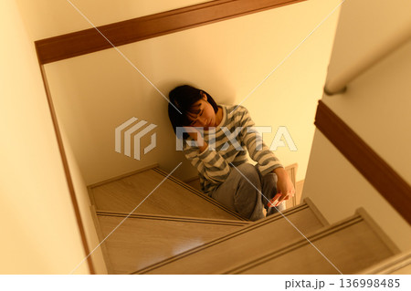 階段で落ち込む女性 136998485