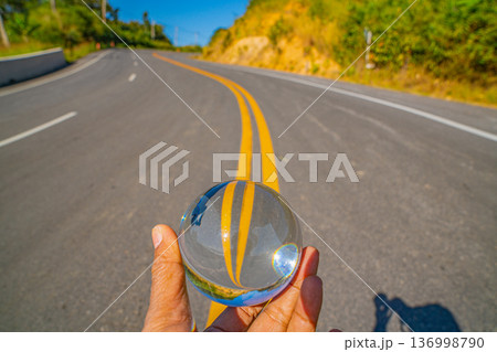 Hand Holding a Crystal Ball Revealing the Path Beyond the Mountain Mist Hand Holding a Crystal Ball Revealing the Path Beyond the Mountain Mist 136998790