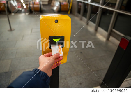 Passenger validating public transport ticket in Prague metro station. Urban transportation system and daily commuting in Czech Republic. 136999032
