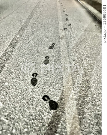 アスファルトに積もった雪の足跡 136999501