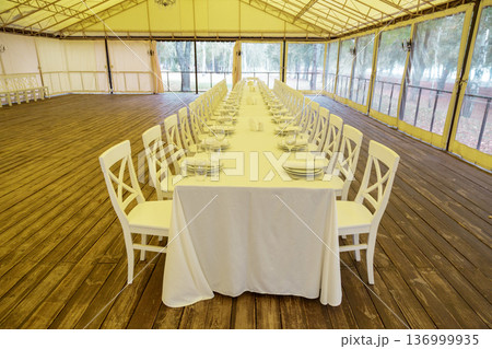 Long banquet table in event tent Long banquet table in event tent 136999935