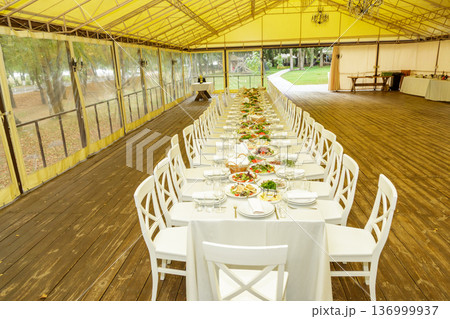 Long banquet table in event tent 136999937