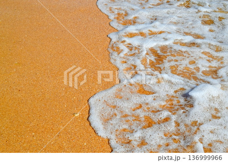 A sandy seashore with waves and foam. Background, cover, splash screen, space for text. A sandy seashore with waves and foam. Background, cover, splash screen, space for text. 136999966