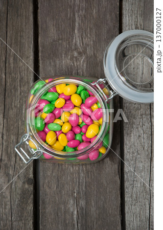 Colorful sweet candy in glass jar on wooden background. 137000127
