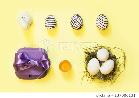 Creative easter composition with painted eggs, violet box and nest Creative easter composition with painted eggs, violet box and nest 137000131