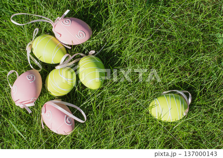 Easter painted pastel color eggs with ribbon in basket on green grass. Easter painted pastel color eggs with ribbon in basket on green grass. 137000143