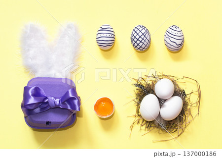 Creative easter composition with painted eggs, violet box and nest 137000186