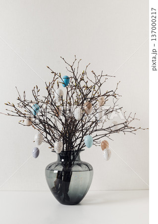 Easter branches with decorative eggs in glass vase Easter branches with decorative eggs in glass vase 137000217
