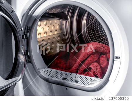 Towels inside dryer drum open appliance door. Textile ready for drying cycle household concept. Domestic laundry routine idea.. Towels inside dryer drum open appliance door. Textile ready for drying cycle household concept. Domestic laundry routine idea.. 137000399