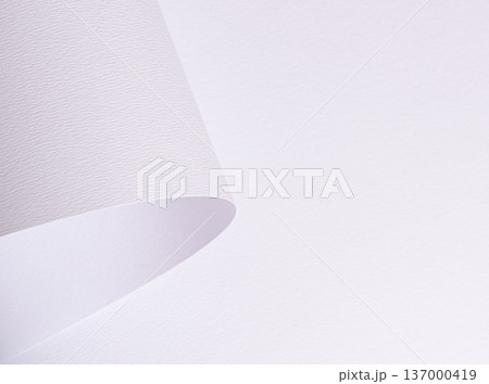 White textured paper with curved lifted sheet corner. Fine grain surface forms minimal composition. Clean background for branding. 137000419