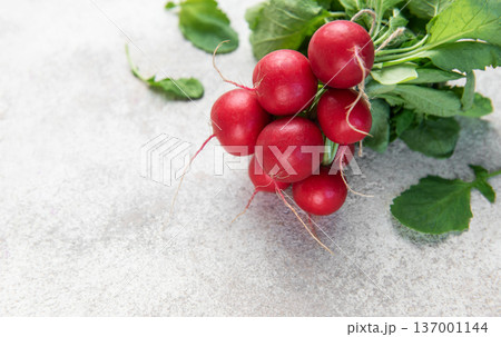 Fresh organic radishes with green leaves on light background 137001144