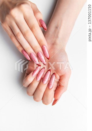 Woman's hands showing long pink glitter stiletto nails 137001150
