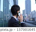 オフィス街で電話をする若手ビジネスマン 137001645