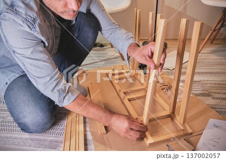 Handyman assembling wooden furniture for home improvement 137002057