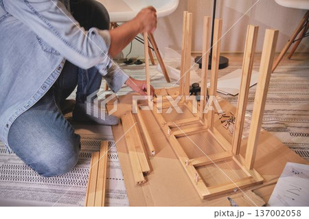 Man assembling flat pack furniture at home for renovation 137002058