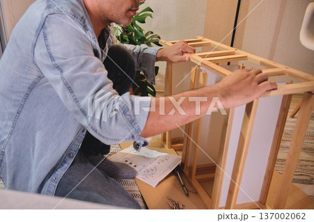 Man assembling flat pack furniture for home improvement 137002062