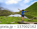 A lone hiker pauses on a rocky peak, gazing at the breathtaking mountainous terrain below. Sporty woman hiking in Switzerland alps. Heathy lifestyle, sport, beauty in nature. Grindelwald valley, Swizz 137002162