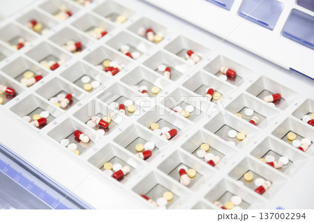 一包化のためにトレイに並べられた錠剤とカプセル 一包化のためにトレイに並べられた錠剤とカプセル 137002294